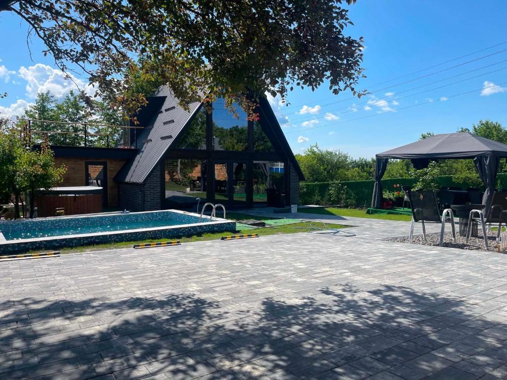 Curtea cu piscina, casa A-frame și foișorul